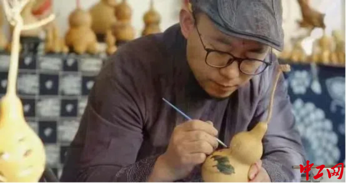 亢剛在葫蘆上作畫。