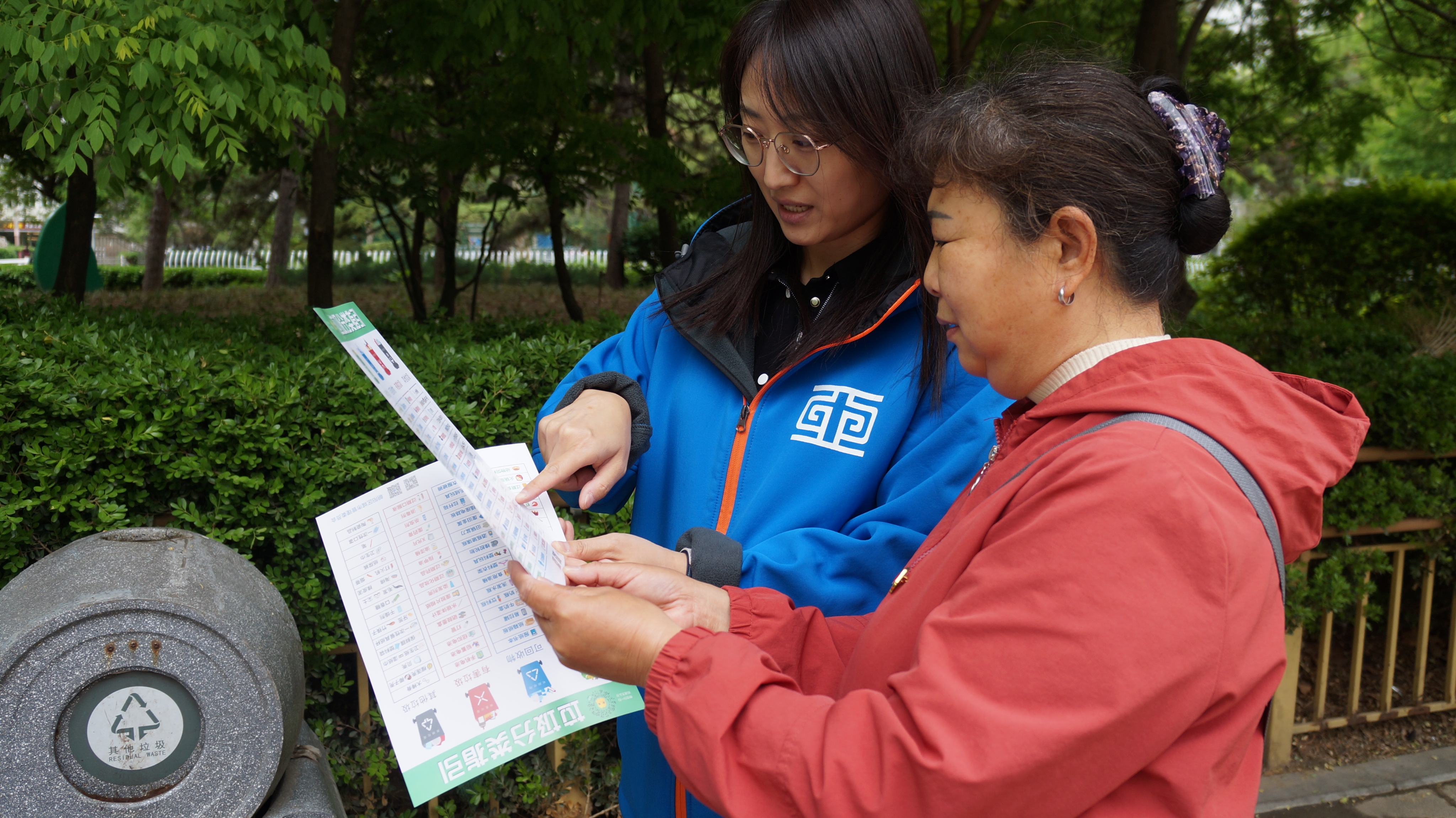 王媛媛（左）指導(dǎo)網(wǎng)格員做好垃圾分類動員工作